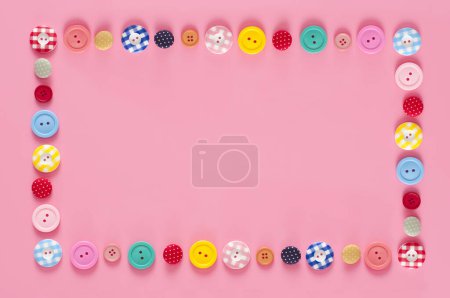 Téléchargez les photos : Vue du haut des boutons colorés sur fond rose - en image libre de droit