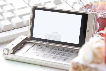 Téléchargez les photos : Vue rapprochée de l'appareil téléphonique moderne isolé sur fond de table blanche - en image libre de droit