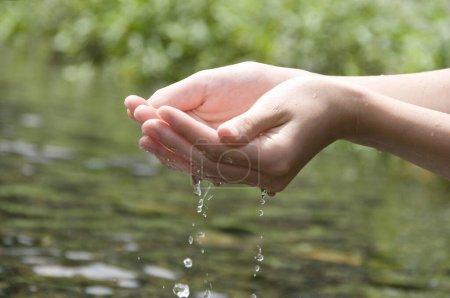 Foto de Mujer lavándose las manos al aire libre. Agua potable natural en la palma. Manos con agua salpicada - Imagen libre de derechos