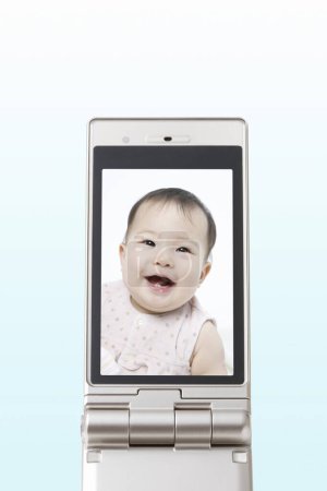Photo for Portrait of beautiful asian kid on the mobile phone screen - Royalty Free Image
