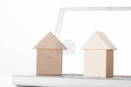 Foto de Portátil con modelos de casa en mesa blanca - Imagen libre de derechos