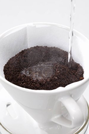 Téléchargez les photos : Vue rapprochée de verser du café chaud dans une tasse blanche - en image libre de droit