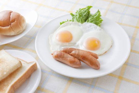 Foto de Un plato de comida con huevos, salchichas y pan - Imagen libre de derechos