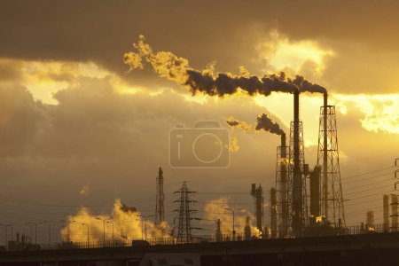 Photo for Industrial factory with pipes against sunset sky - Royalty Free Image
