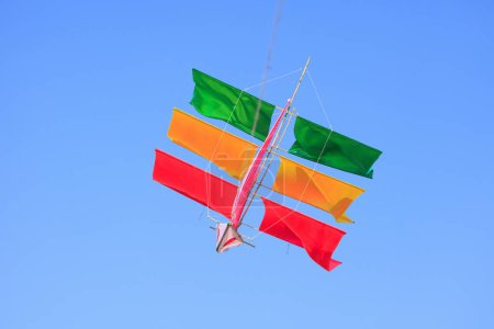 Photo for Colorful kite flying against blue sky - Royalty Free Image