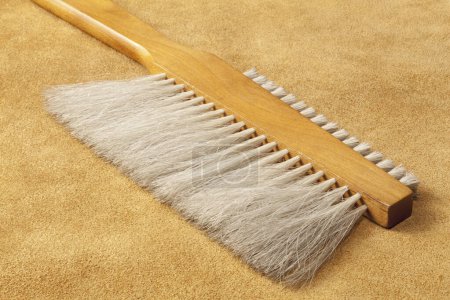 Photo for Brown broom object on a yellow background - Royalty Free Image
