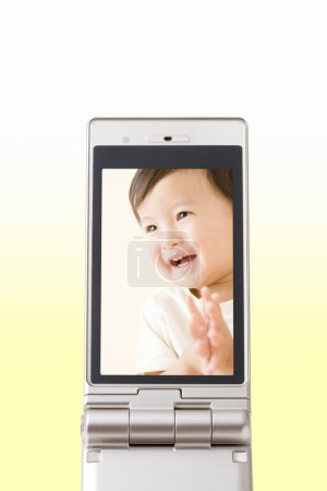 Téléchargez les photos : Portrait de belle asiatique gosse sur l "écran de téléphone mobile - en image libre de droit