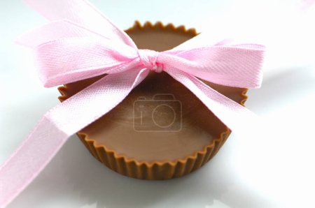 Photo for Chocolate cake in pink bow on background, close up - Royalty Free Image