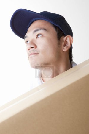 Photo for Tired delivery man with  cardboard box in warehouse - Royalty Free Image