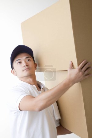 Photo for Delivery man with  cardboard boxes in warehouse - Royalty Free Image