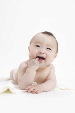 Téléchargez les photos : Portrait studio de bébé asiatique adorable en couche sur fond blanc - en image libre de droit