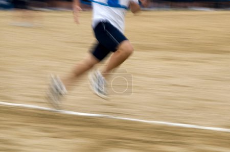 Téléchargez les photos : Vue floue du mouvement du coureur qui court sur le stade de course - en image libre de droit
