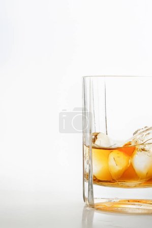 Foto de Vaso de whisky con cubitos de hielo sobre fondo blanco - Imagen libre de derechos