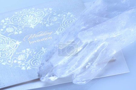 Foto de Hermosa invitación de boda blanca y guantes de novia de encaje - Imagen libre de derechos