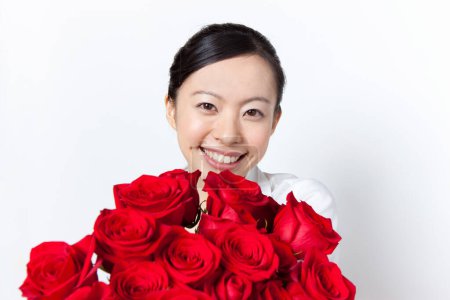 Foto de Joven asiático mujer con rojo rosas ramo - Imagen libre de derechos