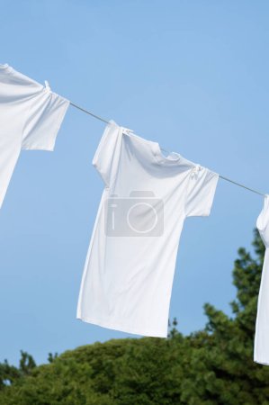 Photo for Clothes drying in line against blue sky - Royalty Free Image