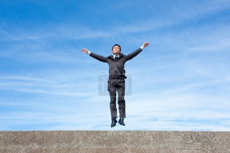 Photo for Portrait of handsome adult asian businessman on blue sky background - Royalty Free Image