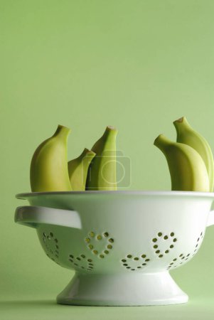 Photo for A white colander with bananas in it on background, close up - Royalty Free Image