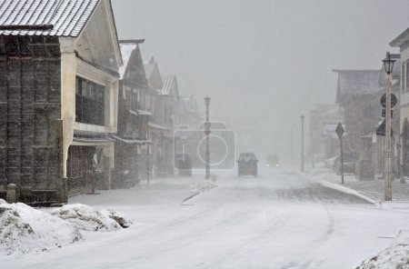 Téléchargez les photos : Snow covered street at the city in winter with snowstorm. - en image libre de droit