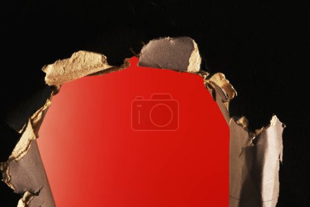 Téléchargez les photos : Trou dans du papier déchiré sur fond rouge - en image libre de droit
