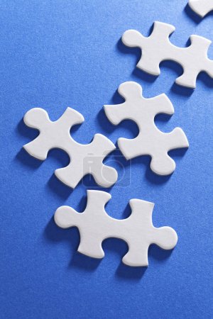 Téléchargez les photos : Un groupe de pièces de puzzle blanc sur une surface bleue - en image libre de droit