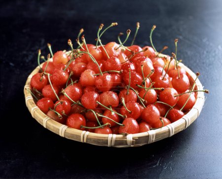 Foto de Cerezas rojas en un tazón en el fondo, de cerca - Imagen libre de derechos