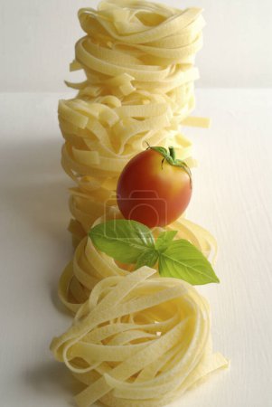 Foto de Un tomate y pasta sobre una mesa blanca - Imagen libre de derechos