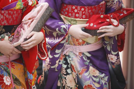Photo for Two young Asian women wearing traditional Japanese costume, mid section - Royalty Free Image