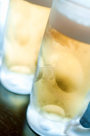 Foto de Cerveza fría en vasos de hielo sobre fondo, de cerca - Imagen libre de derechos