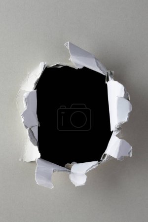 Photo for Hole in torn paper on a black background - Royalty Free Image