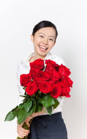 Téléchargez les photos : Jeune femme asiatique avec bouquet de roses rouges - en image libre de droit
