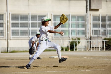 Téléchargez les photos : Lanceur garçon japonais jouant au baseball, concept Little League - en image libre de droit