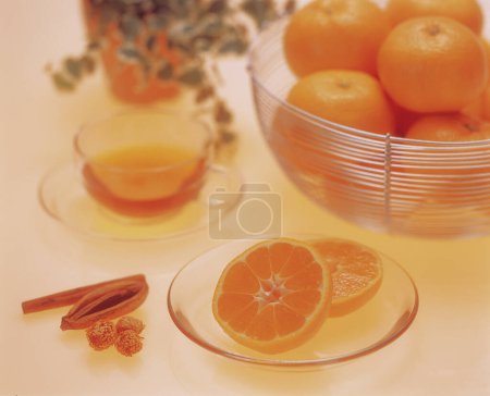 Photo for Orange and cinnamon on the white background with a cup of tea - Royalty Free Image