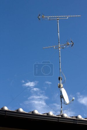 Téléchargez les photos : Antenne satellite sur le toit et ciel bleu - en image libre de droit