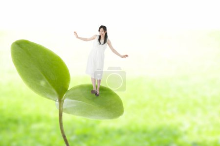 Photo for Tiny asian woman standing on green leaf of sprout - Royalty Free Image