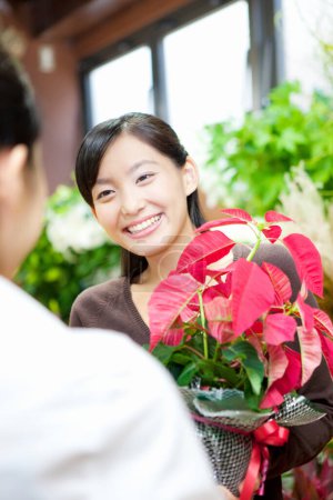 Foto de Retrato de joven florista japonesa con cliente en tienda de flores - Imagen libre de derechos