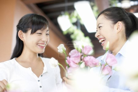 Téléchargez les photos : Portrait de jeunes femmes japonaises fleuristes dans la boutique de fleurs - en image libre de droit