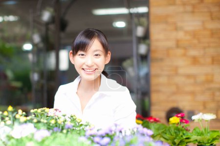 Téléchargez les photos : Portrait de jeune japonaise fleuriste travaillant dans la boutique - en image libre de droit