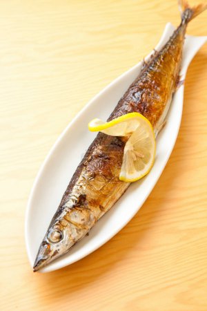 Téléchargez les photos : Une assiette de poisson avec un citron et des baguettes - en image libre de droit