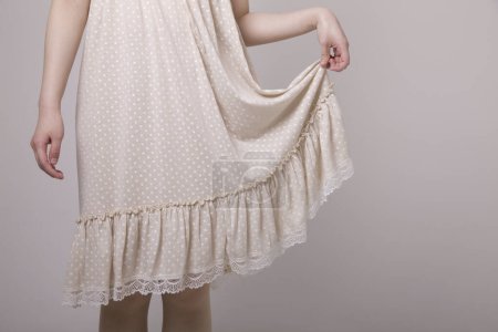 Foto de Mujer con vestido de algodón blanco sobre fondo gris - Imagen libre de derechos