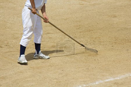 Téléchargez les photos : Joueur de baseball avec râteau et baseball - en image libre de droit
