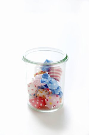 Téléchargez les photos : Bonbons dans un bocal en verre sur un fond blanc - en image libre de droit
