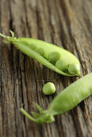 Photo for Green peas on a wooden table background, close up - Royalty Free Image