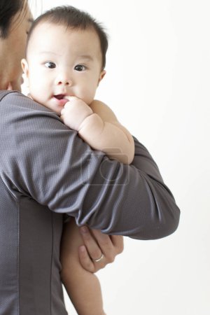 Photo for Happy Japanese boy on mothers hands, Woman holding little son on hands, closeup - Royalty Free Image