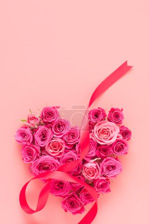 Photo for Pink roses with heart shape and ribbon on pastel  background. - Royalty Free Image