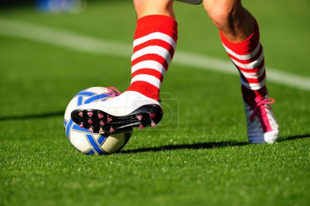 Foto de Pelota de fútbol en los pies en el campo - Imagen libre de derechos