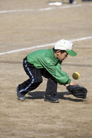 Foto de Japonés niño jugando béisbol en campo - Imagen libre de derechos