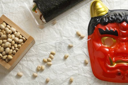 Rouleau Eho-maki, haricots pour mame-maki (lancer de haricots), et masque de démon sur la table. Image de Setsubun