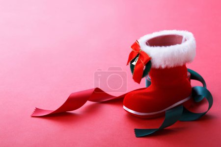 Photo for Christmas red shoe with ribbons and bow isolated on  background. - Royalty Free Image
