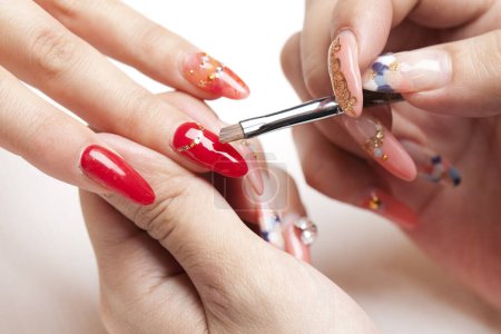 Photo for Red manicure on female nails on a beautiful background - Royalty Free Image